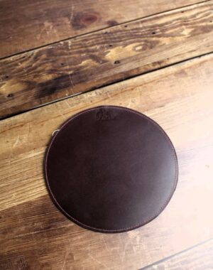 Tapis de souris rond en cuir bordeaux avec un fil de couture contrasté fuchsia