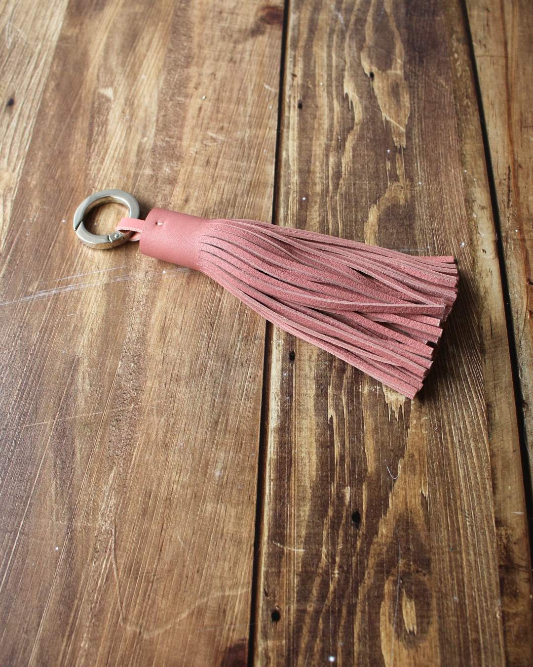 Porte-cles-pompon-cuir Porte clés pompon en cuir vieux rose à franges et avec un anneau ouvert mousqueton